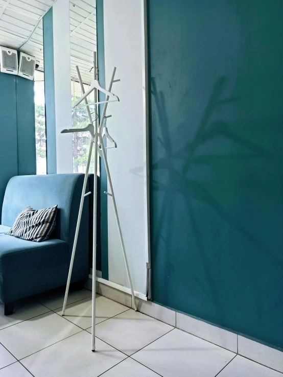 an umbrella - like tree - like object sits next to a blue couch