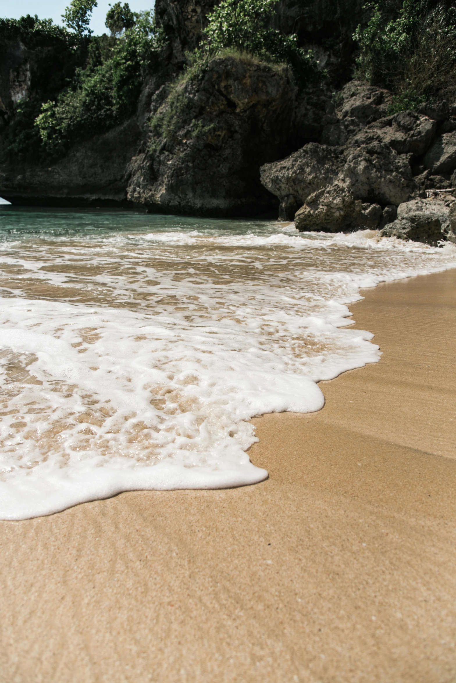 a sandy beach with waves coming toward it