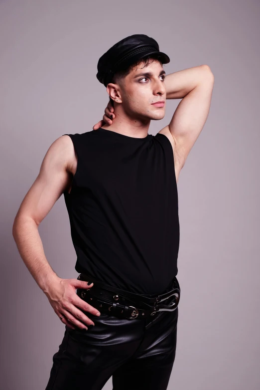 a young man with a hat wearing black leather pants