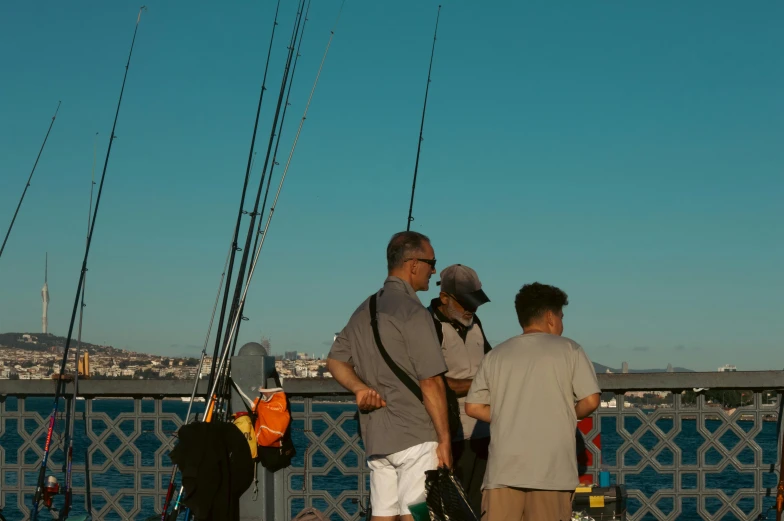 men are standing together holding fishing rods