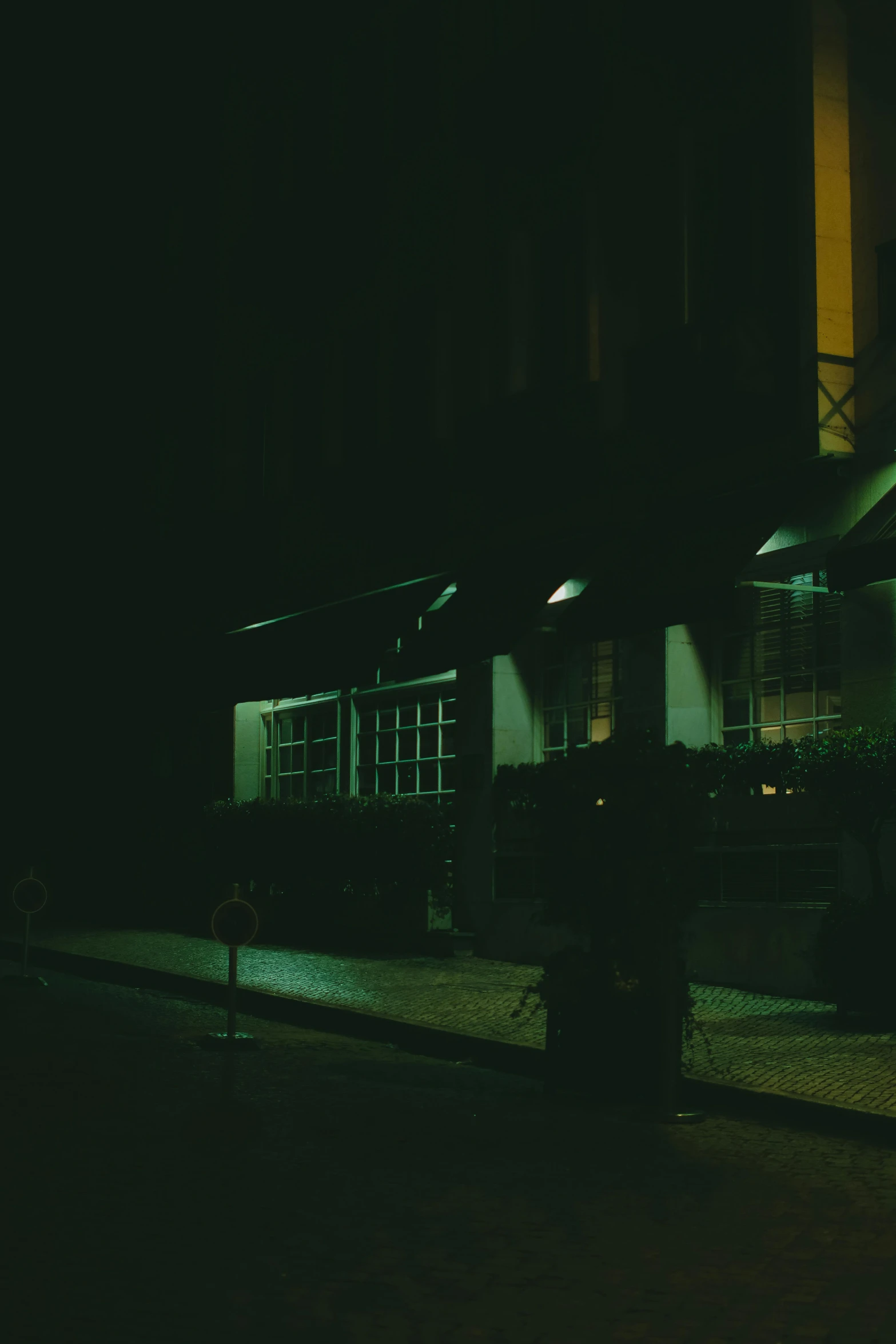 an empty dark street with two buildings and a fire hydrant