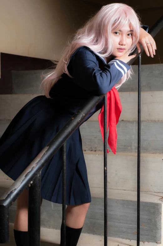 a girl with pink hair and a black shirt is standing at the top of some stairs