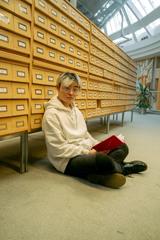 a woman sitting on the floor reading a book