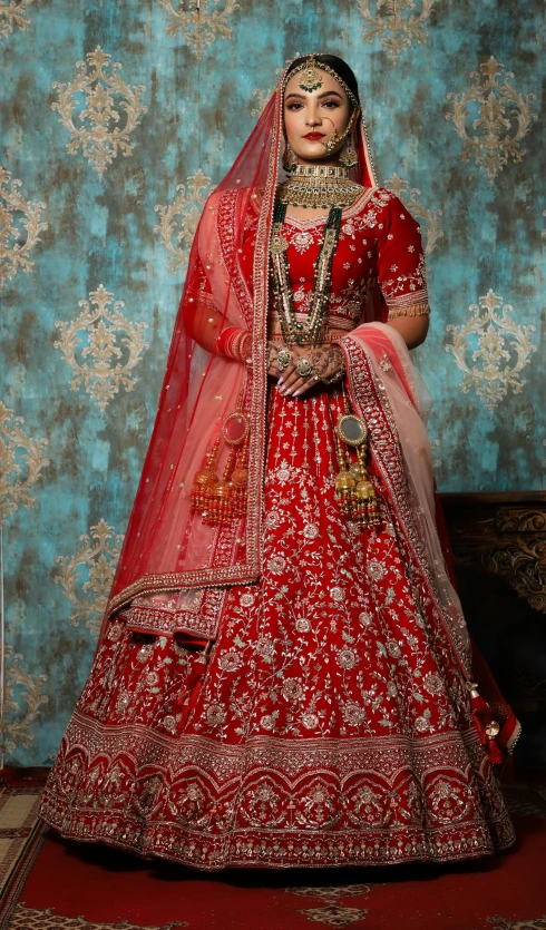 indian bridal posing for a pograph in her bridal gown