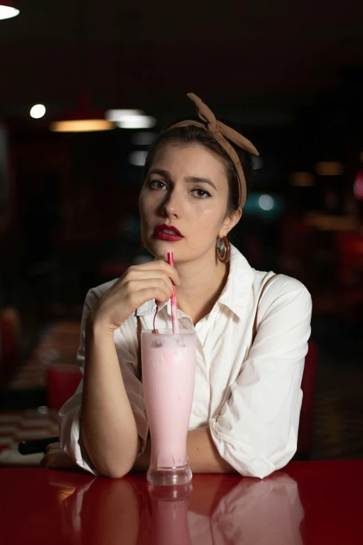 a woman drinking a smoothie with her fingers