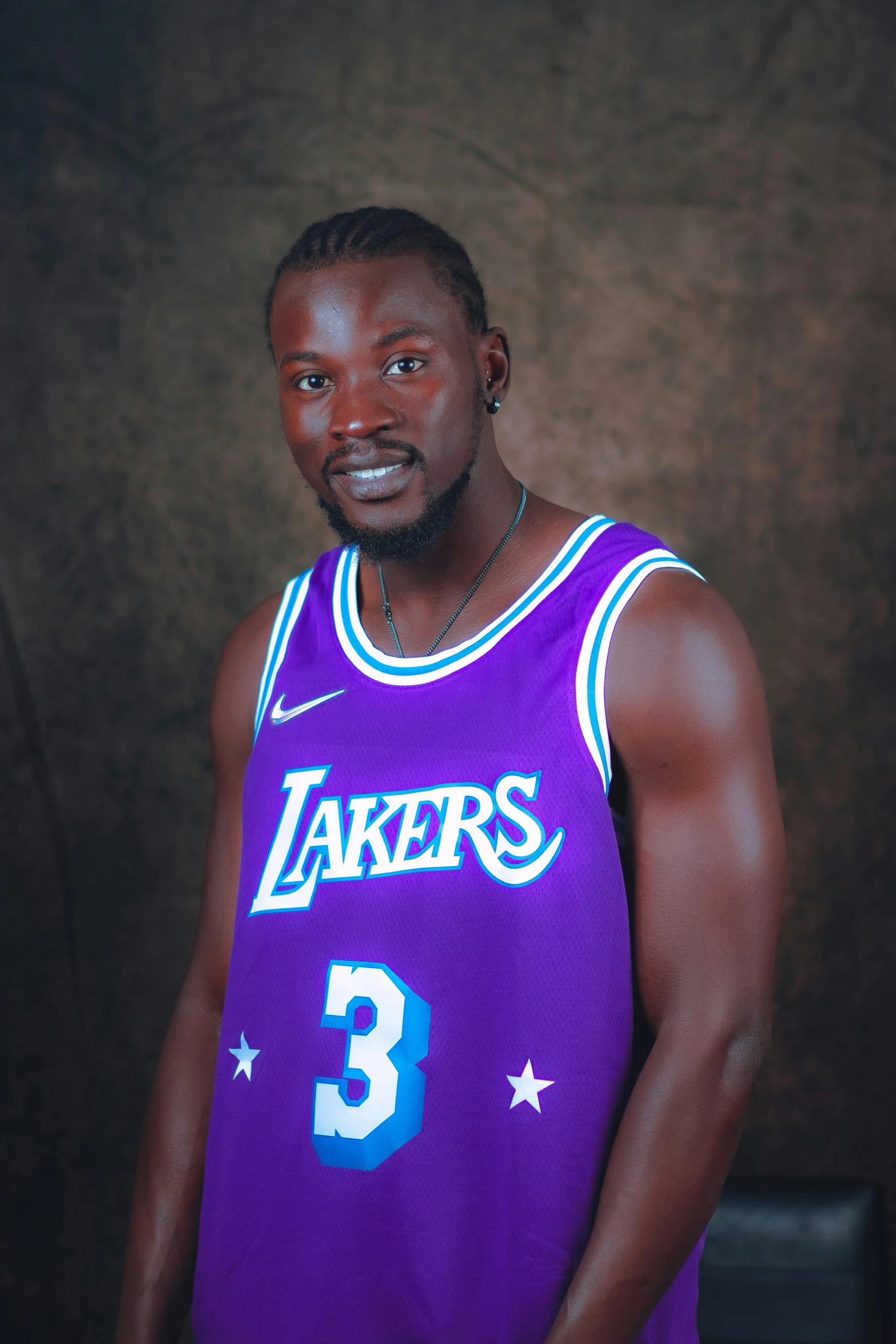 a man in a purple basketball uniform with his hands on his hips