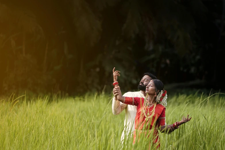 an indian bride and groom taking a selfie in the tall grass