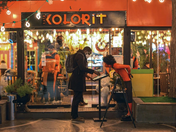 two men stand in front of a store door