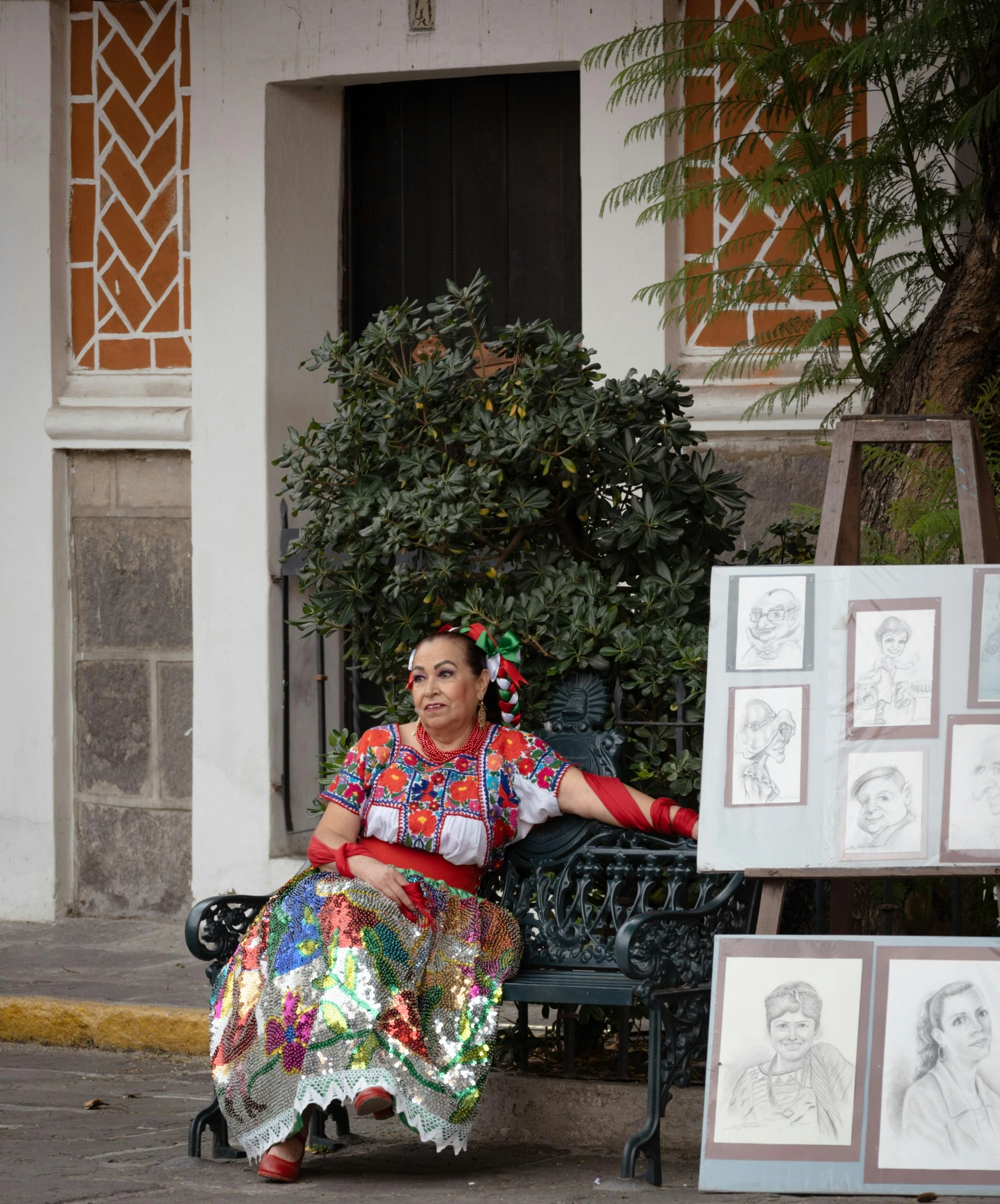 a woman sitting on a bench in front of a display of art