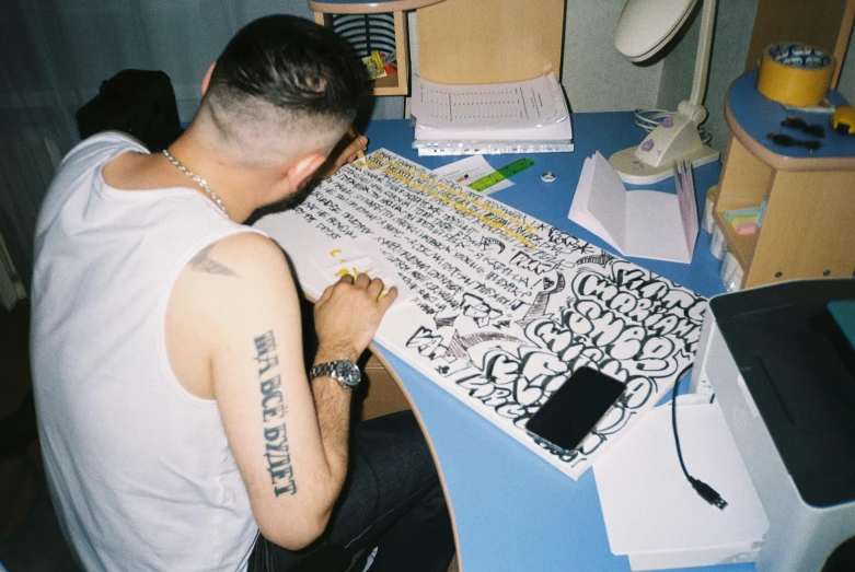 a man sitting at his computer desk in the middle of writing