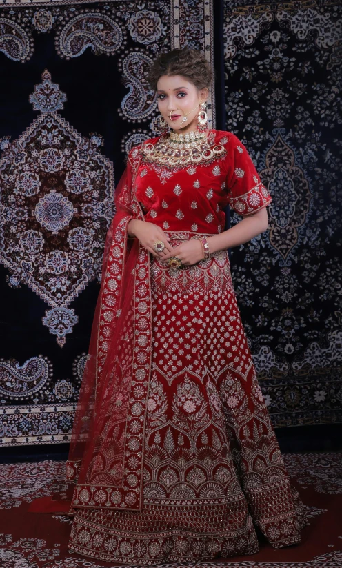 a woman is standing in front of a curtain wearing a red bridal