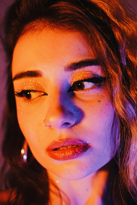 young female wearing ear rings and orange and pink filter