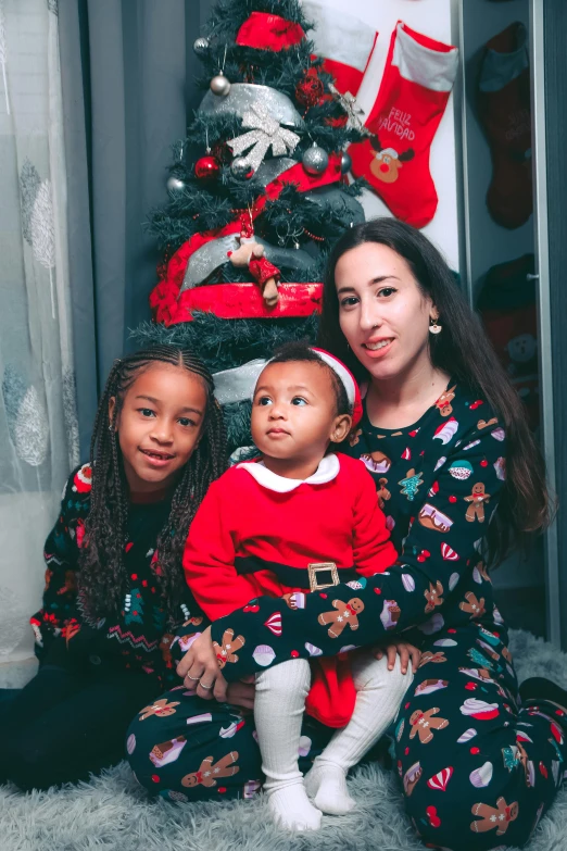 there is a woman and two little girls wearing matching pajamas