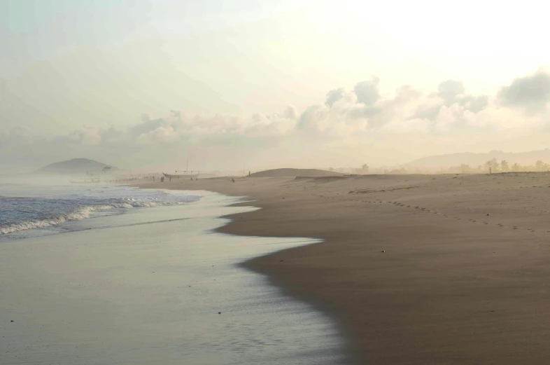 a couple of people are walking along a beach