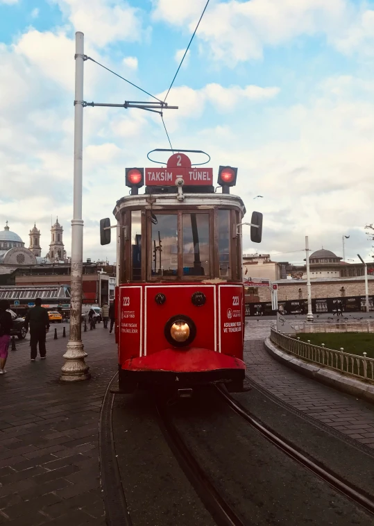 a red trolley train moving along the tracks