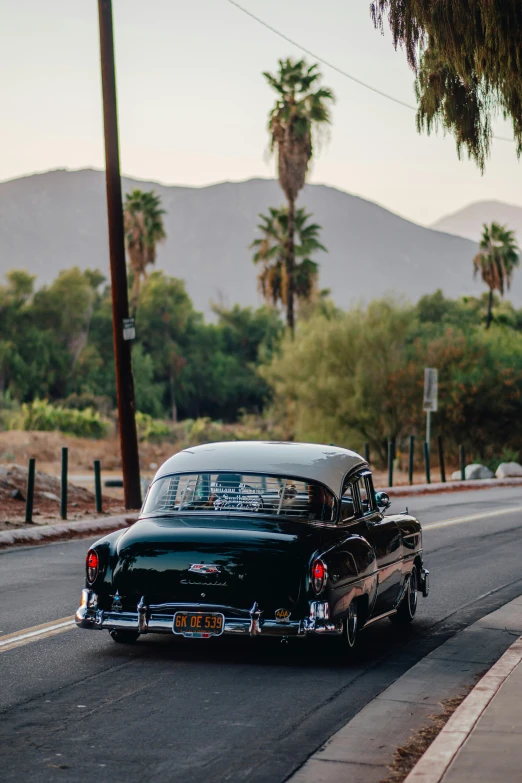 a classic car driving down the street