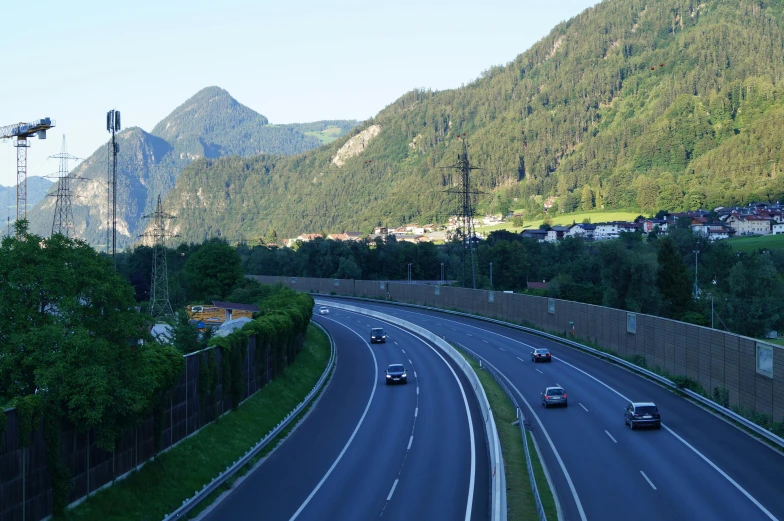 two cars driving down an empty road between mountains