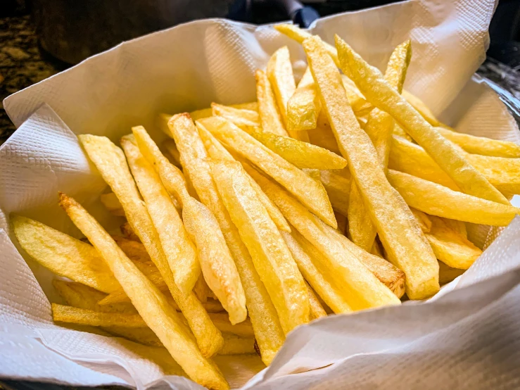 a white bowl filled with french fries covered in grease