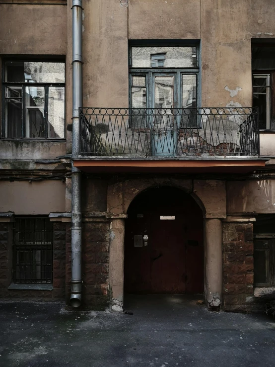 a brown and grey building with balconies on the second floor