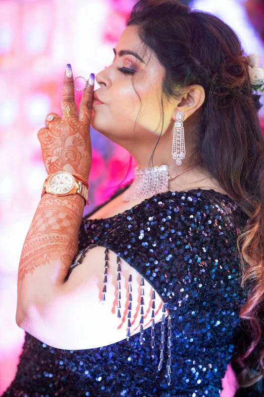 a woman is dressed in blue with an intricate lace design holding a gold watch