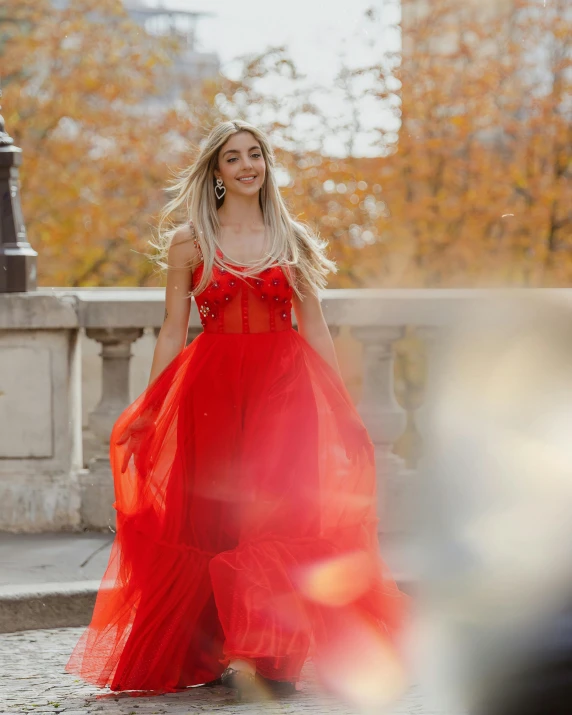 a woman wearing a red evening dress and high heels