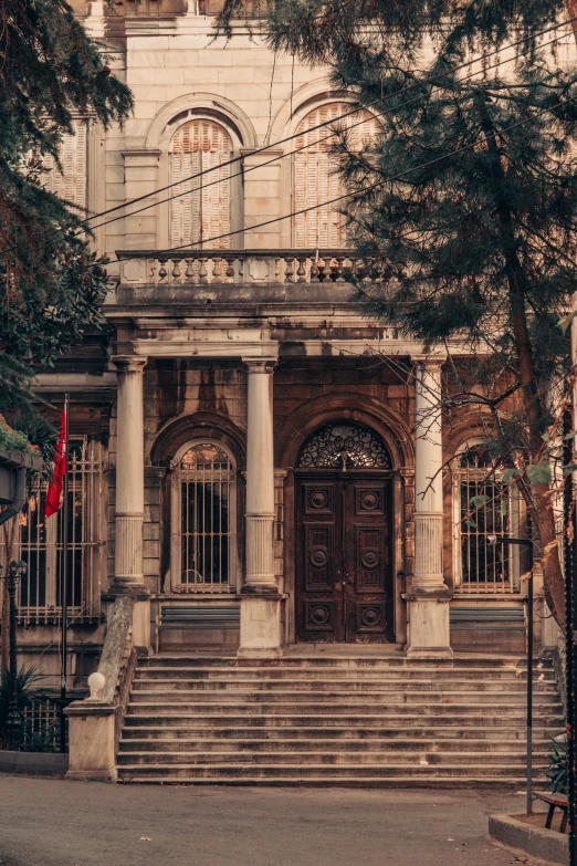 a building with some stairs and trees by the door