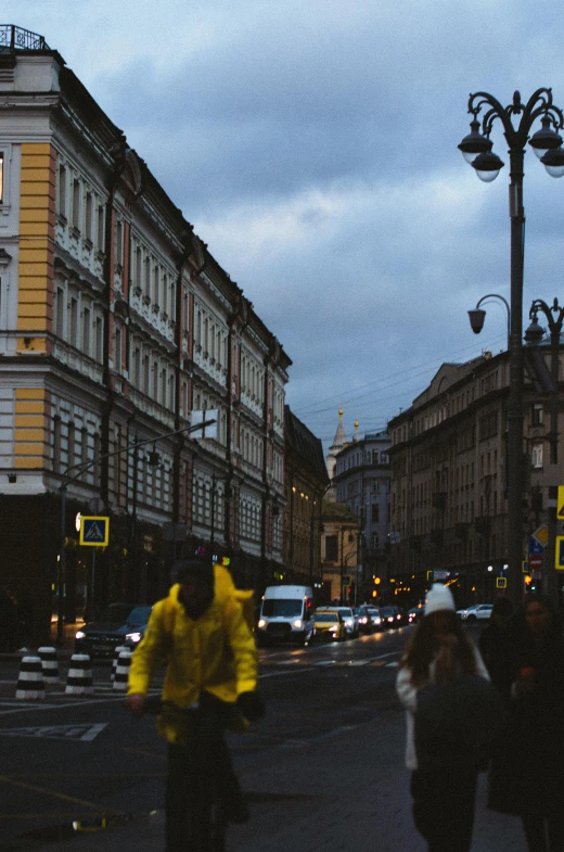 several people are crossing the street in front of some very tall buildings