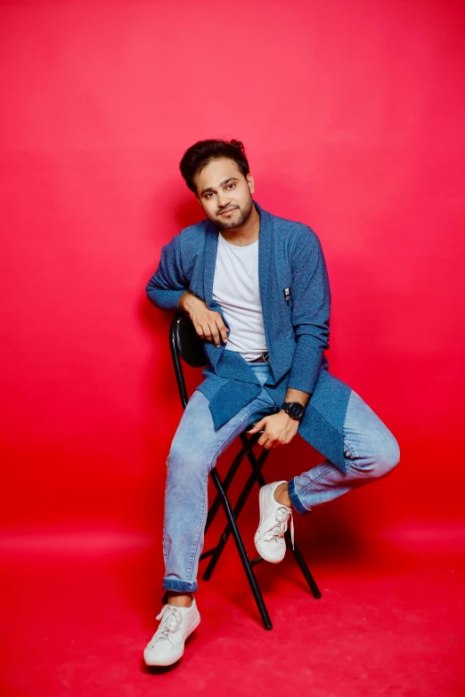 the young man sits on top of a chair