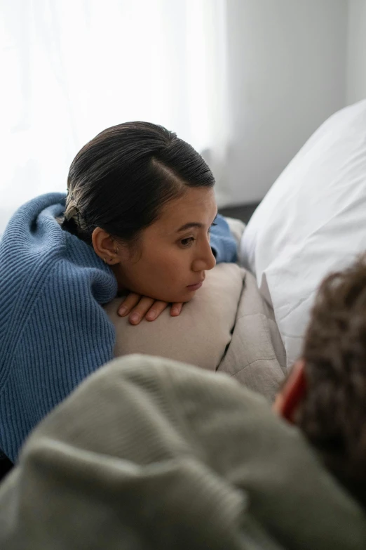 a woman laying on the couch while talking to another man