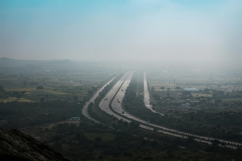 traffic traveling down a road on a foggy day