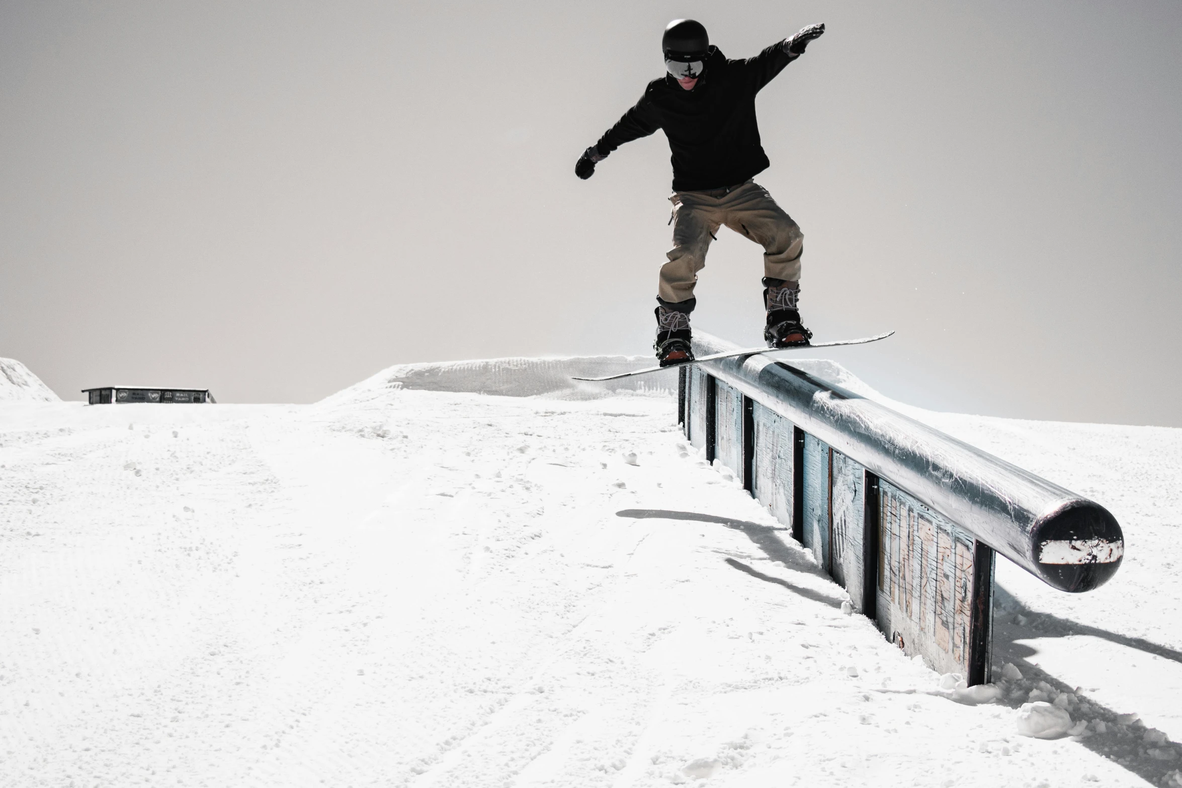 a man on a snowboard grinding over a rail