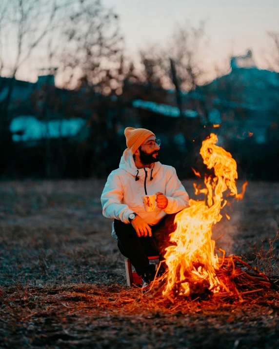 the person is sitting in front of a fire