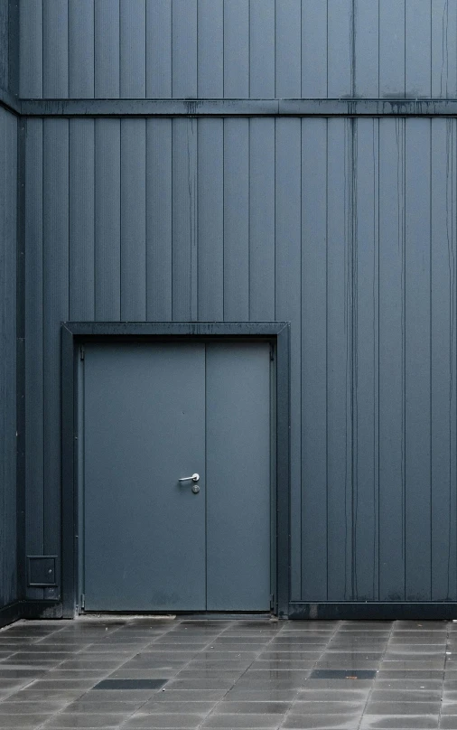 blue metal wall with open doors in an industrial area