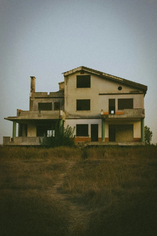 a building sits next to a lush green hillside