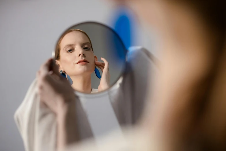 a girl looking in the mirror brushing her teeth