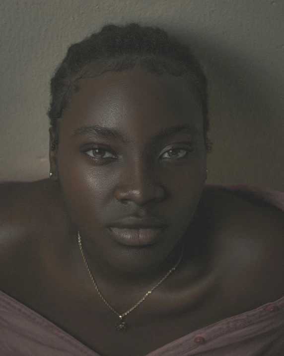 black woman with bleaches and tattoos sitting on a bed