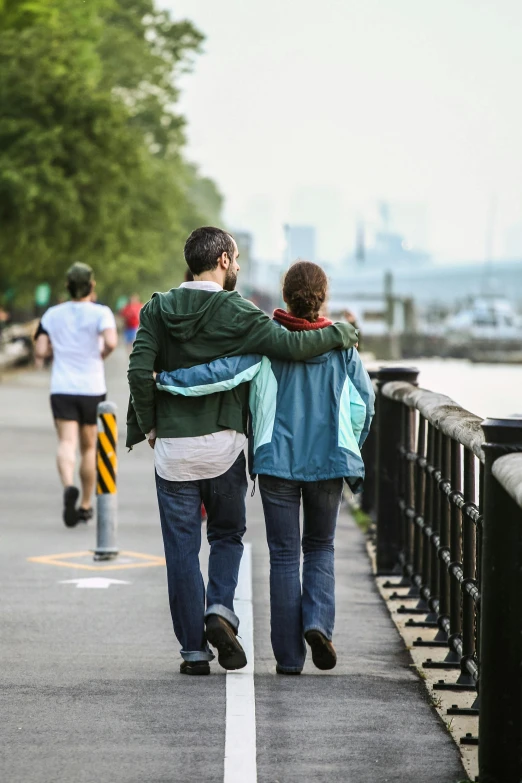 the man and woman walk along the side of a road