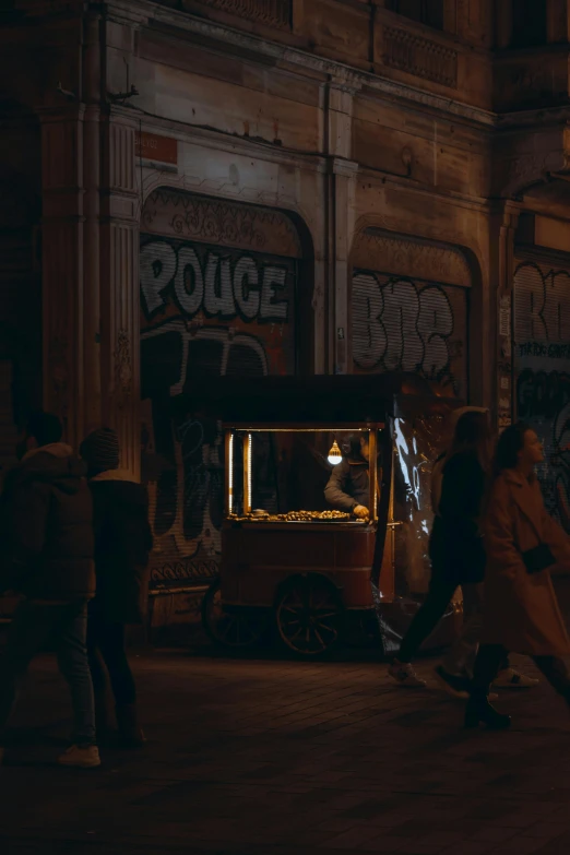 a street vendor selling popcorn in an alley at night