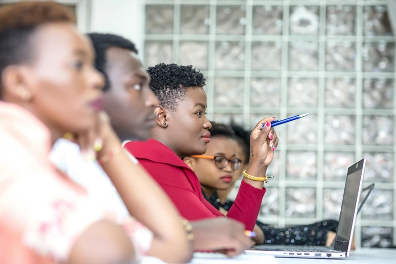 a group of women in front of a laptop computer