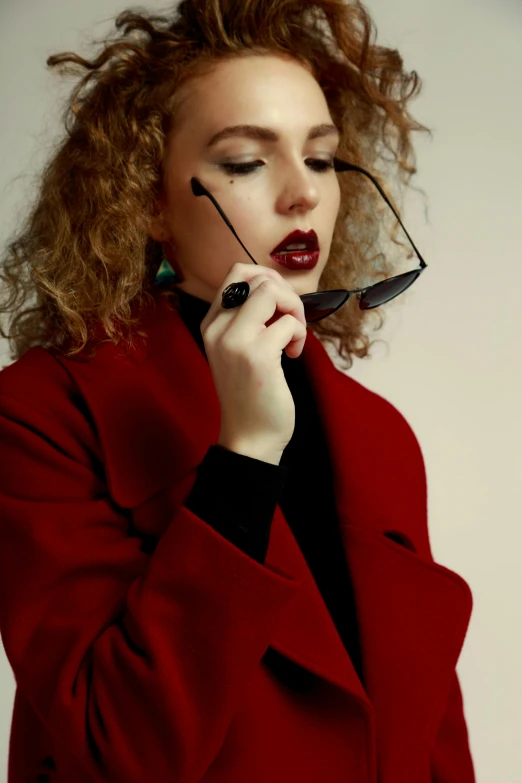 a woman wearing glasses and a red coat