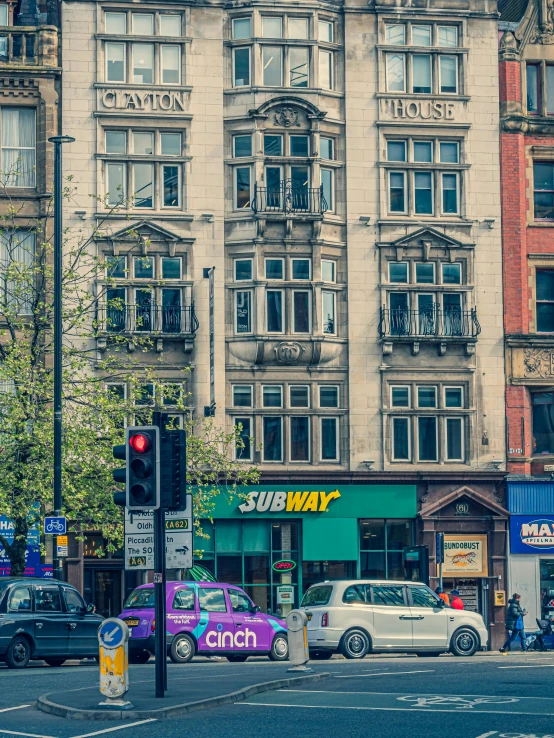 cars parked along the side of a street next to tall buildings