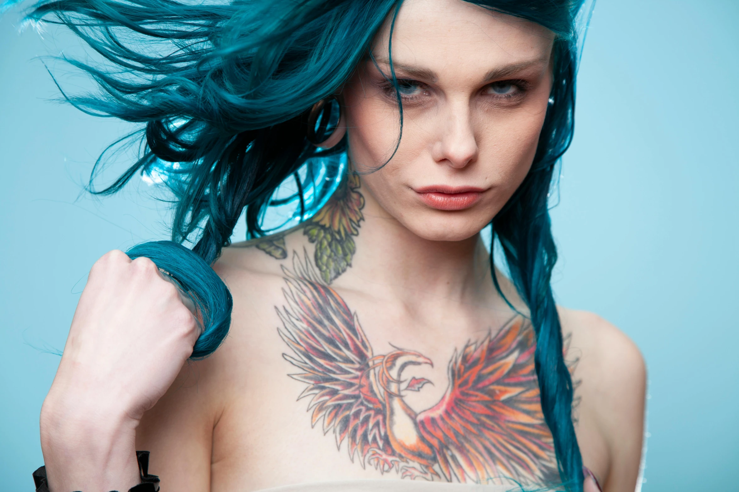 a woman with long green hair with a tattoo on her back