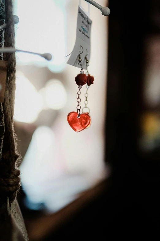 a heart hanging on a string with a card attached to it