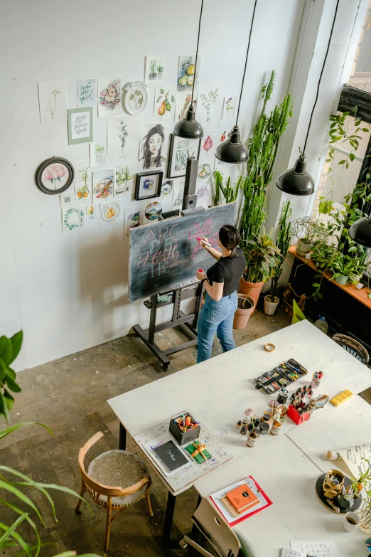 a young man stands by a large wall mounted easel