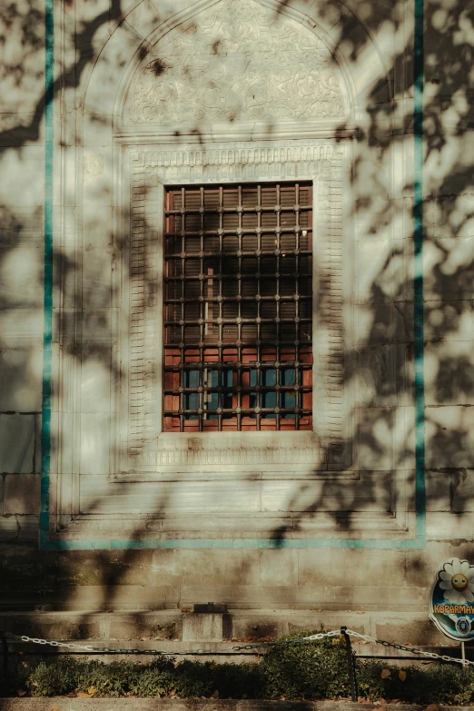 a wall that has a window and a blue scooter parked in front of it