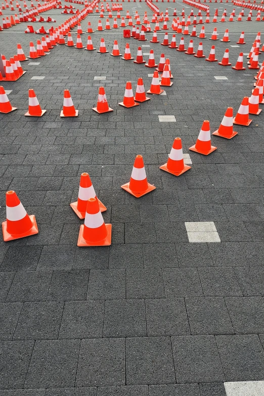 large open area with orange and white cones and traffic signs