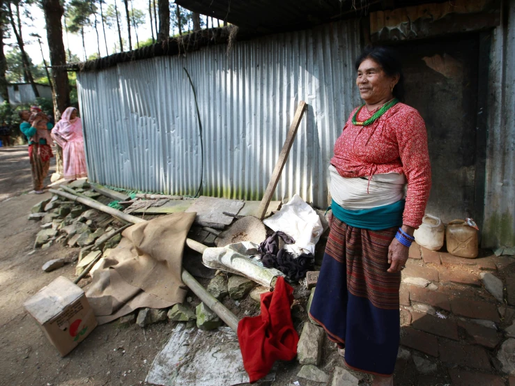 the woman is standing in front of the wall next to her house