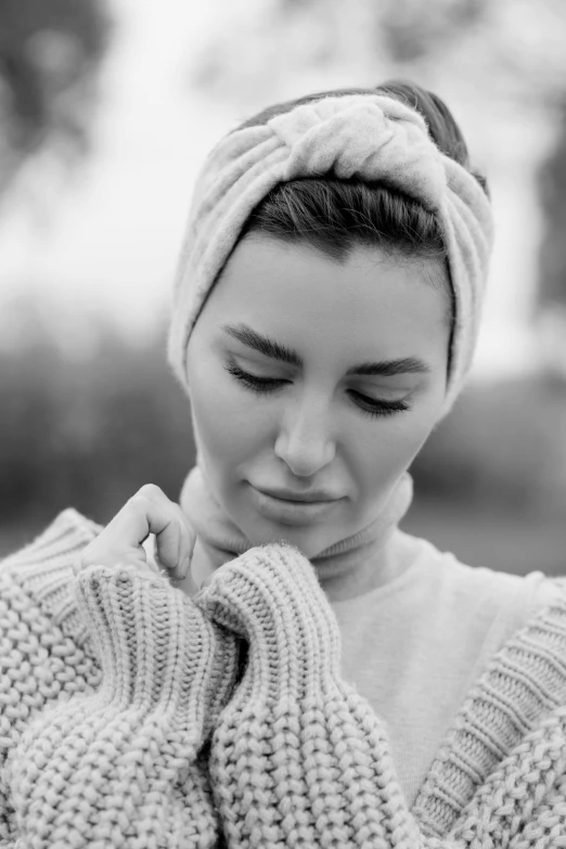 a woman in a sweater and head wrap