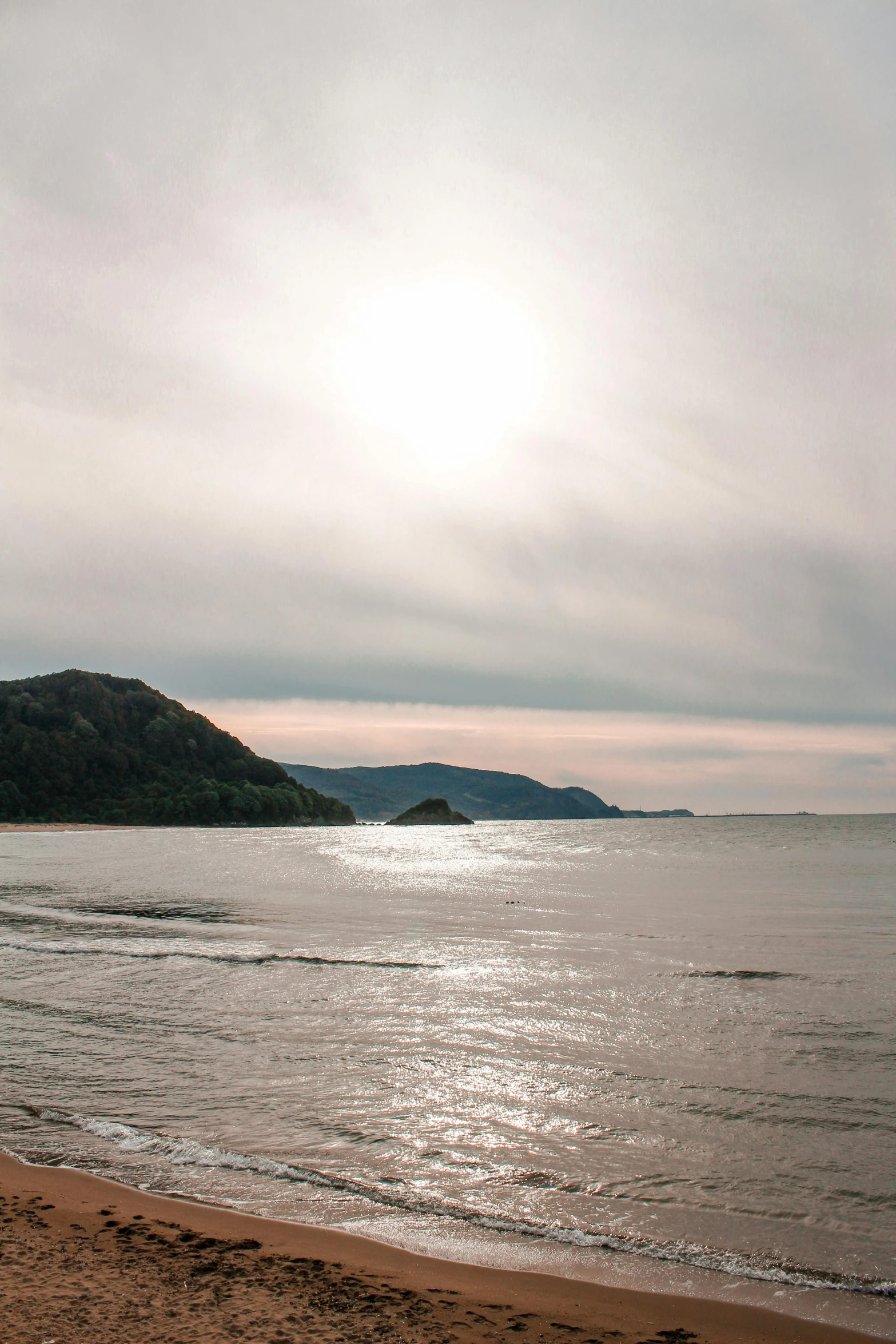 a person walks on the sand near the ocean