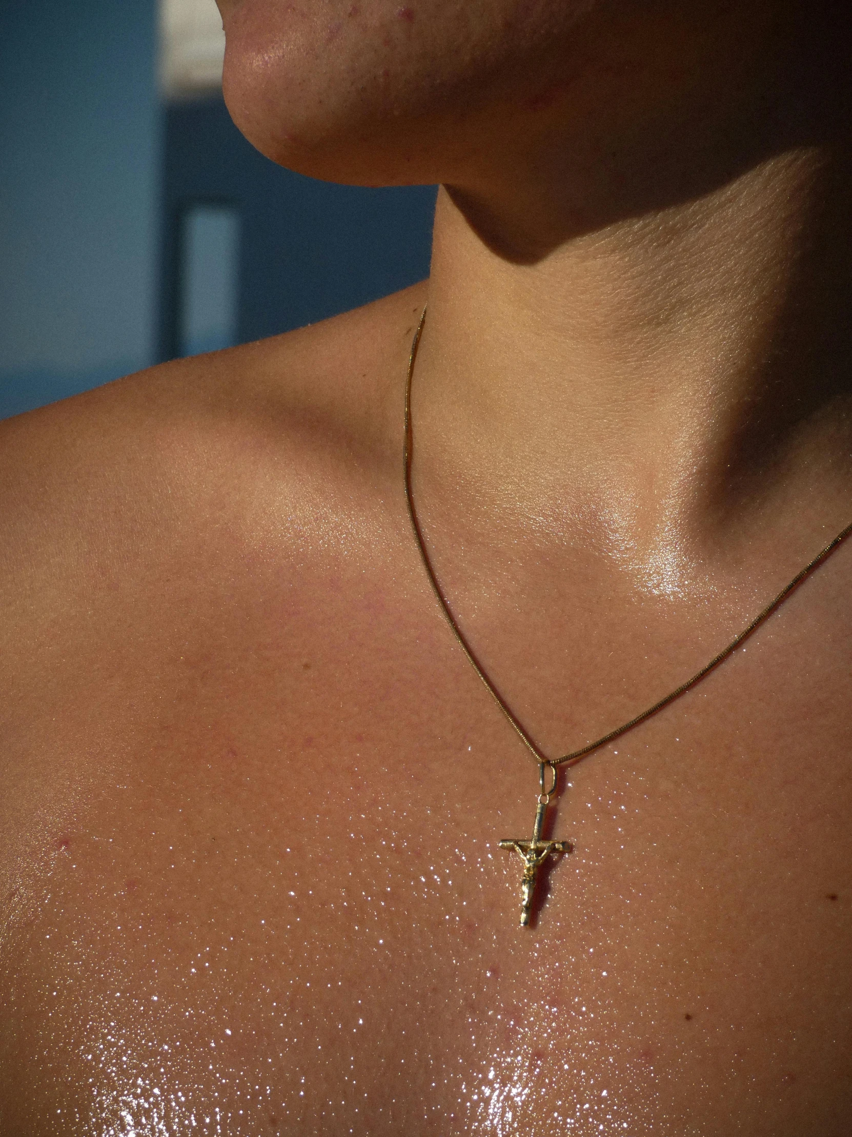 a woman is wearing a shiny shirt with a cross on it